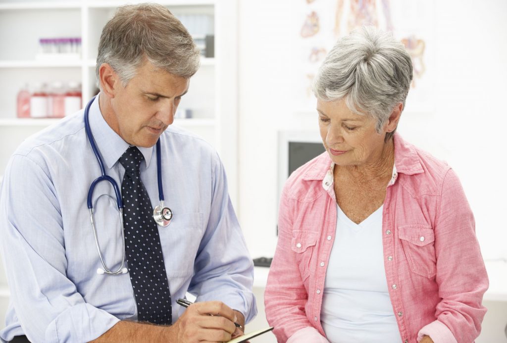 Woman Sitting Next to Her Doctor Image