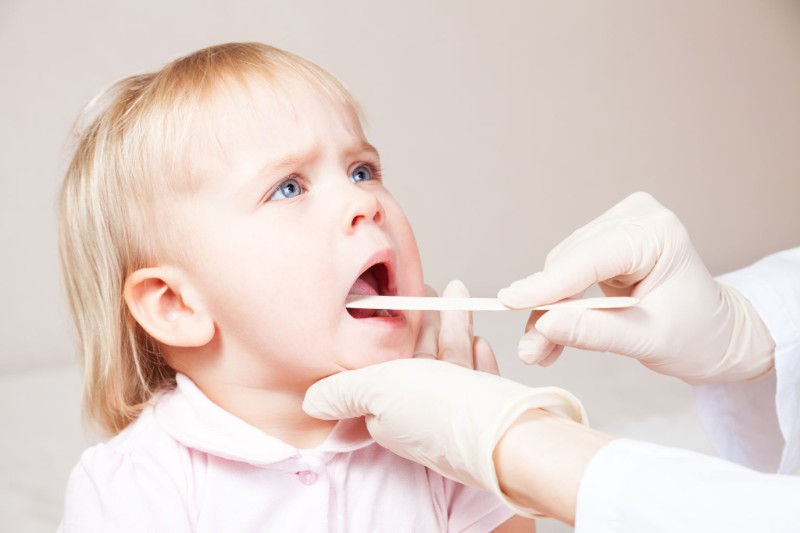 Doctor Looking at the Throat of a Small Child Image
